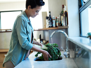 Woman, vegetable and washing with food, cleaning and hygiene for health and wellness. Lady,...
