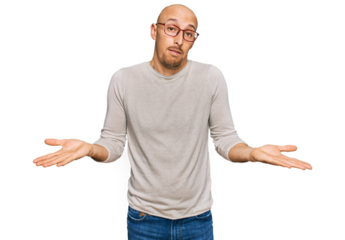 Bald man with beard wearing casual clothes and glasses clueless and confused expression with arms and hands raised. doubt concept.