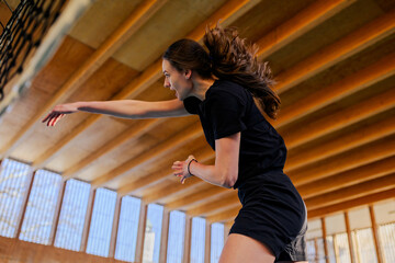 Female volleyball player in action hitting a ball while playing at the net