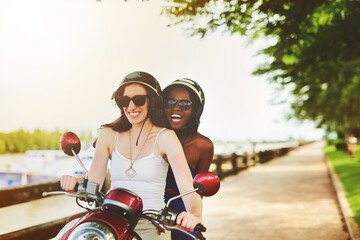 Female couple, motor scooter and smile outside with laugh for fun in summer on vacation or holiday....