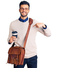 Young handsome hispanic man wearing leather bag and drinking take away coffee pointing finger to one self smiling happy and proud