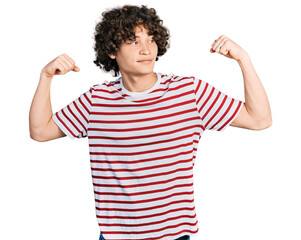 Caucasian teenager wearing casual clothes showing arms muscles smiling proud. fitness concept.