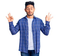 Naklejka premium Handsome latin american young man wearing casual shirt relax and smiling with eyes closed doing meditation gesture with fingers. yoga concept.