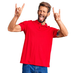 Fototapeta premium Handsome blond man with beard wearing casual clothes shouting with crazy expression doing rock symbol with hands up. music star. heavy concept.