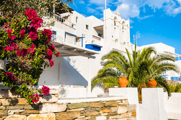 Greek church with palm tree and colorful flowers on street of Kastro village, Sifnos island, Cyclades, Greece