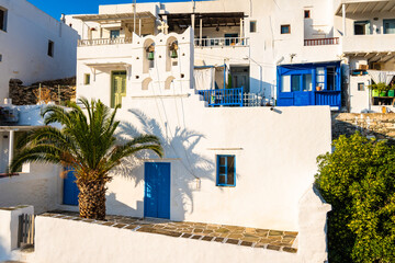 Facade of Greek church with blue door and palm tree on street of Kastro village, Sifnos island, Cyclades, Greece