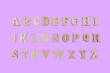 wooden letters of the English alphabet on a pink background