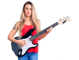 Young beautiful blonde woman playing electric guitar thinking attitude and sober expression looking self confident