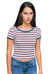 Obraz premium Young hispanic girl wearing casual striped t shirt skeptic and nervous, frowning upset because of problem. negative person.