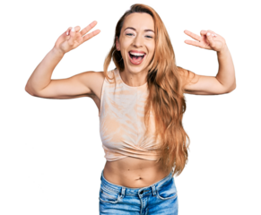 Young caucasian woman doing victory sign and peace gesture smiling and laughing hard out loud because funny crazy joke.