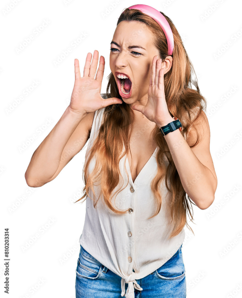 Sticker young caucasian woman wearing casual style with sleeveless shirt shouting angry out loud with hands 