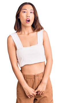 Young beautiful chinese girl wearing casual clothes afraid and shocked with surprise expression, fear and excited face.