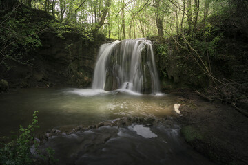 Fototapeta premium Waterfall of Altube inside a beech forest in the province of Alava, in the Basque Country, on a spring morning