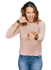 Beautiful young caucasian woman wearing casual sweater smiling doing talking on the telephone...