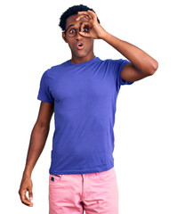 African handsome man wearing casual clothes and glasses doing ok gesture shocked with surprised face, eye looking through fingers. unbelieving expression.