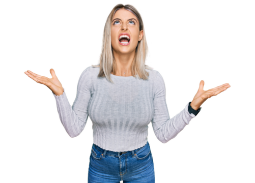 Beautiful blonde woman wearing casual clothes crazy and mad shouting and yelling with aggressive expression and arms raised. frustration concept.