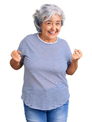 Senior woman with gray hair wearing casual striped clothes very happy and excited doing winner gesture with arms raised, smiling and screaming for success. celebration concept.
