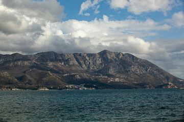 Spring in the mountains, beautiful mountain landscape. View of the mountain range and green trees. Summer, autumn and winter. Budva, Montenegro. Europe. Background. For text. Banner. Postcard. 
