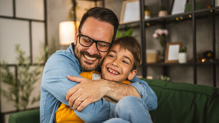 Dad hug son and share love with him spend time together at home