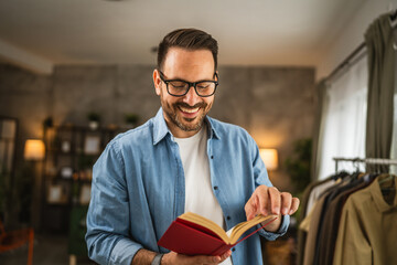Portrait of adult caucasian man with eyeglasses read book at living room happy and relax