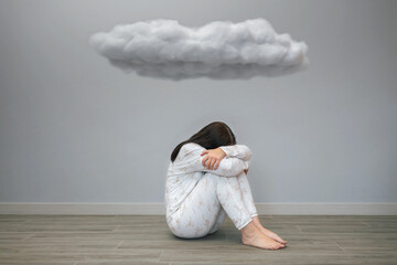 Unrecognizable woman with mental disorder and suicidal thoughts crying sitting under a dark cloud on her room. Negative emotions and bad feelings concept.