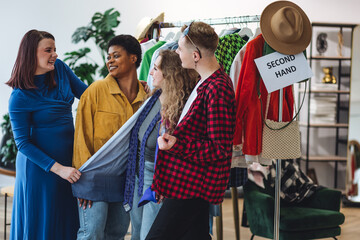 Young people, generation z shopping in a second hand store, vintage finds, branded clothes. Bargain hunting, pre-owned goods, thrift store. Sustainable lifestyle, eco friendly conscious consumerism