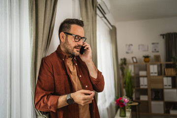 Portrait of adult nervous man stand while talk on mobile phone