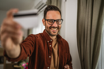 Portrait of adult man shop online with cellphone and hold credit card