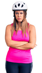 Young beautiful woman wearing bike helmet skeptic and nervous, disapproving expression on face with crossed arms. negative person.