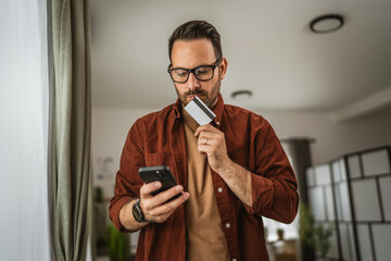 Portrait of adult man kiss credit card after online shopping