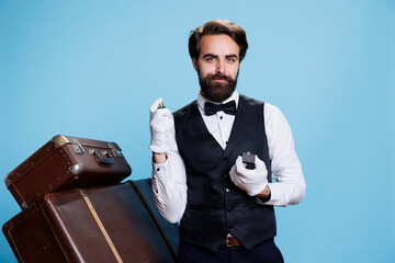 Stylish bellhop applying perfume, using strong bottle of cologne for rich luxurious scent and...