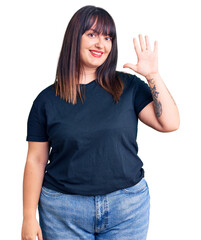 Young plus size woman wearing casual clothes showing and pointing up with fingers number five while smiling confident and happy.