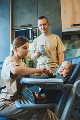 The first complementary food for a baby. A mother feeds puree to her 6-month-old son.