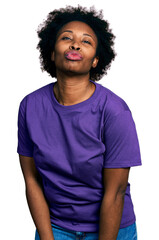 African american woman with afro hair wearing casual purple t shirt looking at the camera blowing a kiss on air being lovely and sexy. love expression.