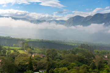 Fototapeta premium Crops and houses between mountains at morning time in a Colombian landscape