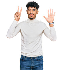 Young arab man wearing casual winter sweater showing and pointing up with fingers number seven while smiling confident and happy.