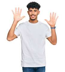 Naklejka premium Young arab man wearing casual white t shirt showing and pointing up with fingers number nine while smiling confident and happy.