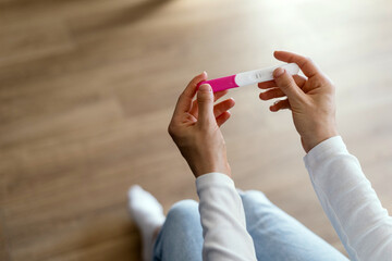 Woman holding pregnancy or ovulation test kit in hands