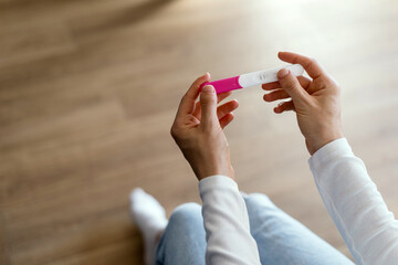 Woman holding pregnancy or ovulation test kit in hands © brizmaker