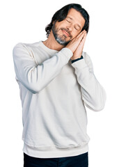 Middle age caucasian man wearing casual clothes sleeping tired dreaming and posing with hands together while smiling with closed eyes.