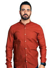 Young hispanic man with beard wearing casual shirt relaxed with serious expression on face. simple and natural looking at the camera.