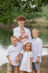Fototapeta premium children, brothers and sisters walk near the lake in the summer, a large family