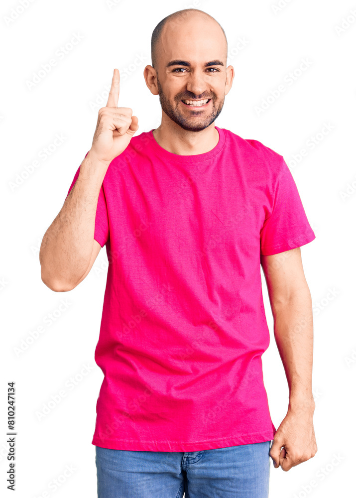 Poster Young handsome man wearing casual t shirt pointing finger up with successful idea. exited and happy. number one.