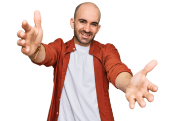 Young hispanic man wearing casual clothes looking at the camera smiling with open arms for hug. cheerful expression embracing happiness.