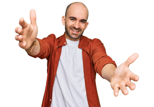 Young hispanic man wearing casual clothes looking at the camera smiling with open arms for hug. cheerful expression embracing happiness.