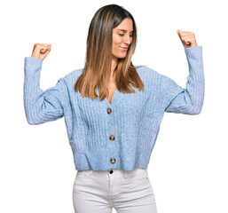 Young woman wearing casual clothes showing arms muscles smiling proud. fitness concept.