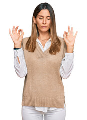 Young woman wearing casual clothes relax and smiling with eyes closed doing meditation gesture with fingers. yoga concept.