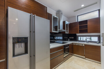 Kitchen in a villa with a large refrigerator and a brown facade set.