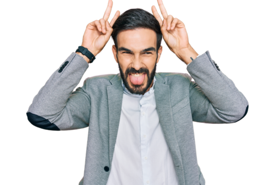 Young hispanic man wearing business clothes posing funny and crazy with fingers on head as bunny ears, smiling cheerful
