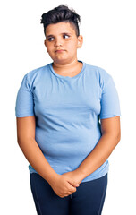 Little boy kid wearing sports workout clothes smiling looking to the side and staring away thinking.
